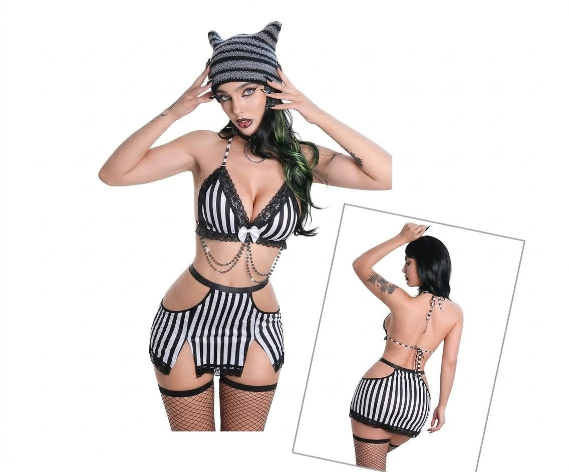 Conjunto a rayas blancas y negras con top triangular, encaje negro, lazo blanco y falda con aberturas; modelo con medias de red y gorro.