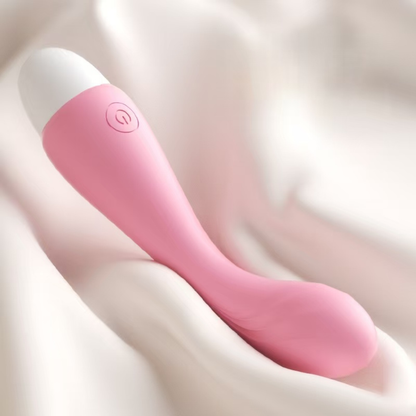Mini vibrador recargable USB color rosa sobre tela suave, vista lateral