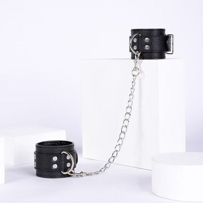 Esposas ajustables negras con cadena y detalles metálicos