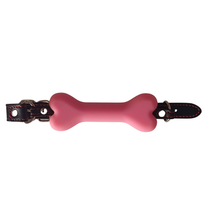 Mordaza rosa en forma de hueso con correa negra ajustable, vista diagonal